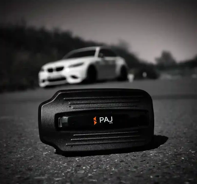 Paj gps power finder 4g placed on the road and a car passing behind it