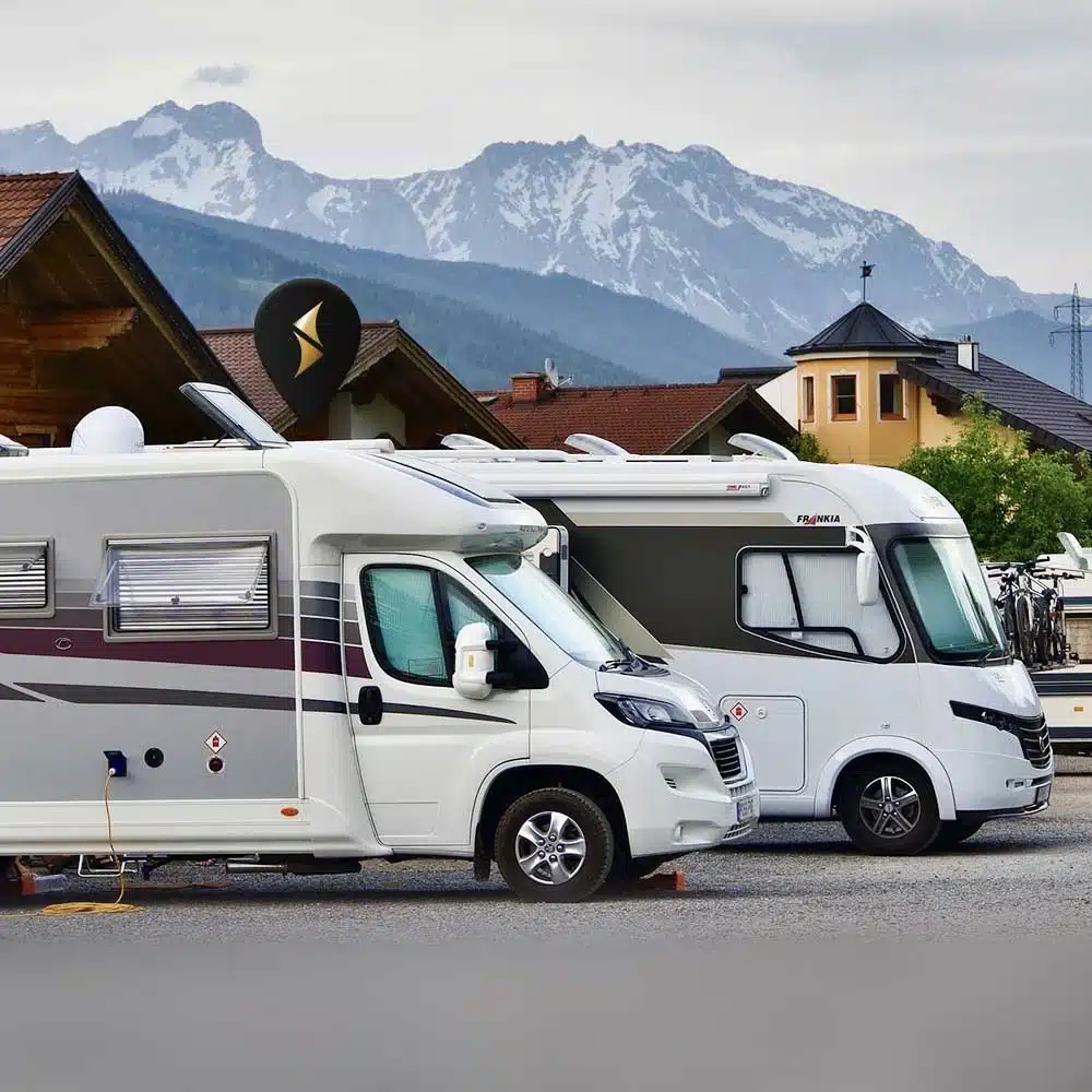 Two motorhomes are parked side by side in the parking lot