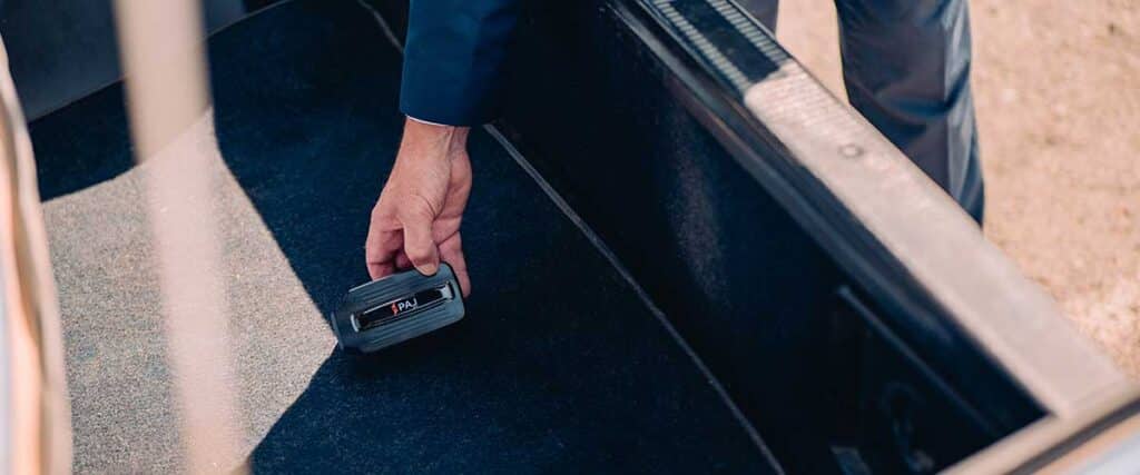 man placing a GPS Tracker inside a car